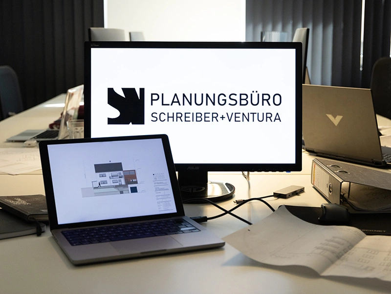 Monitore im Architekturbüro Schreiber und Ventura, die ein Wohnhaus zeigen